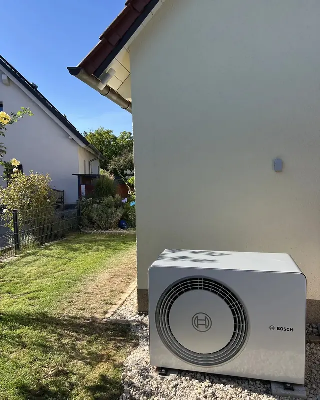 Außeneinheit auf Kiesbett vor einer hellen Hauswand im Garten