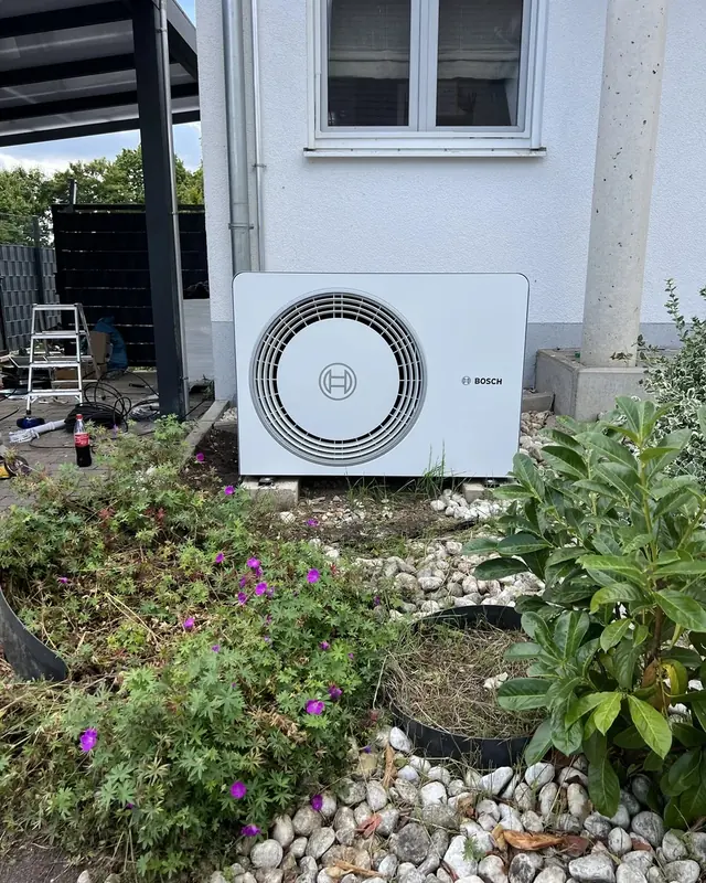 Außeneinheit im Blumenbeet vor der Hauswand