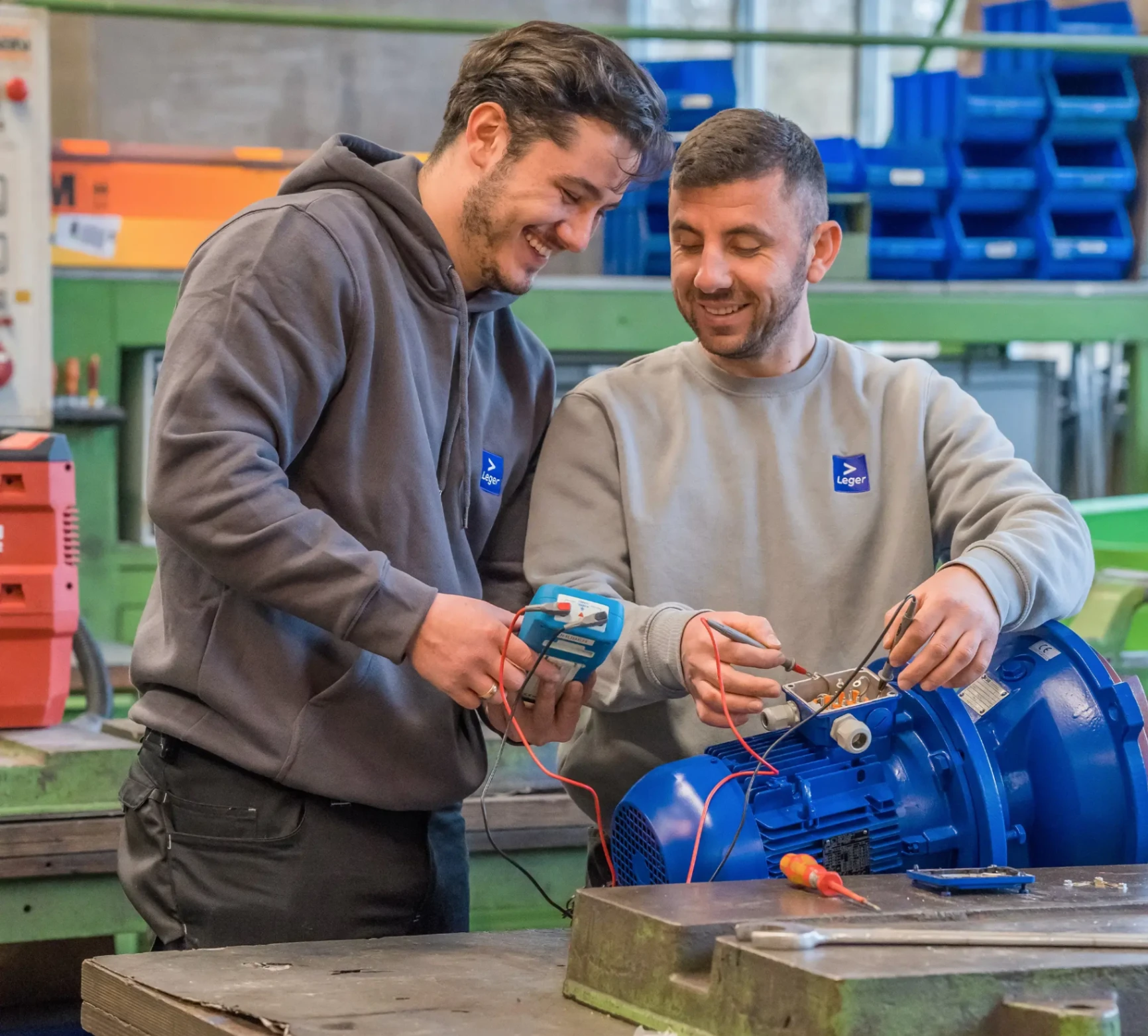 Zwei LEGER-Servicetechniker messen am Motor einer Pumpe
