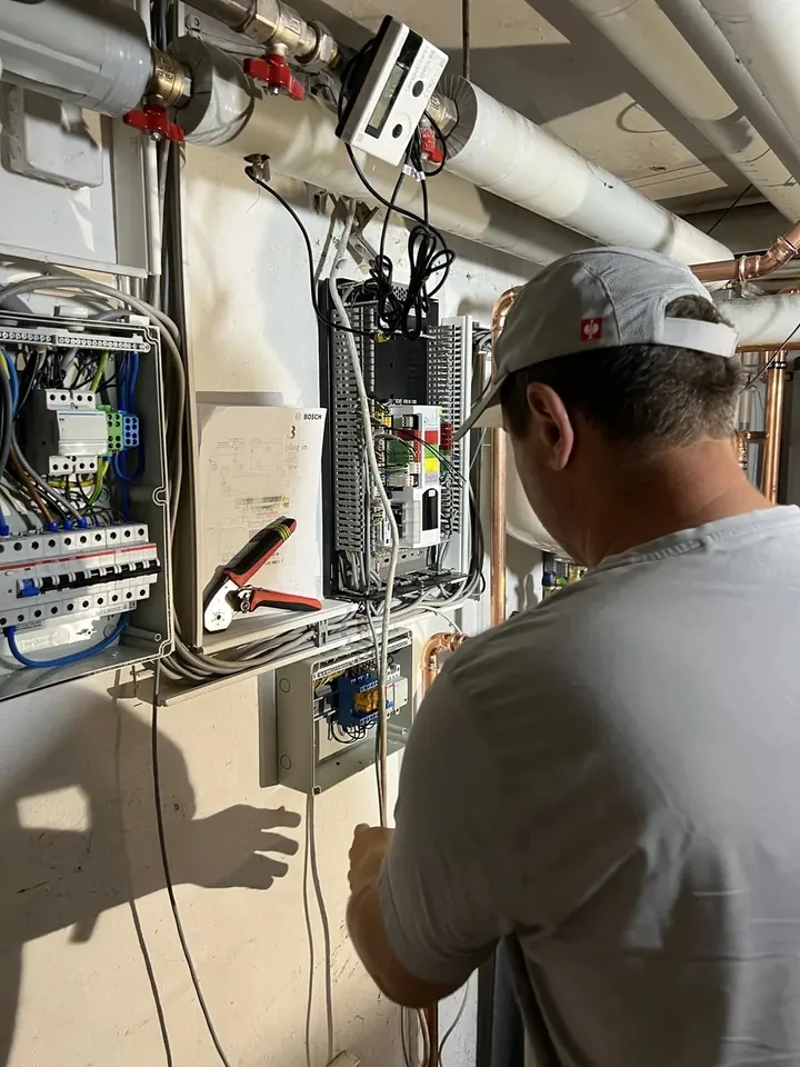 Elektriker verdrahtet die Wärmepumpensteuerung im Zählerschrank