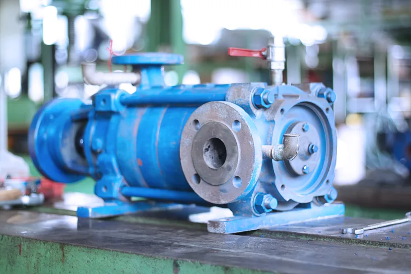 Blaues industrielles Pumpenaggregat mit Flanschanschlüssen auf einer Werkbank